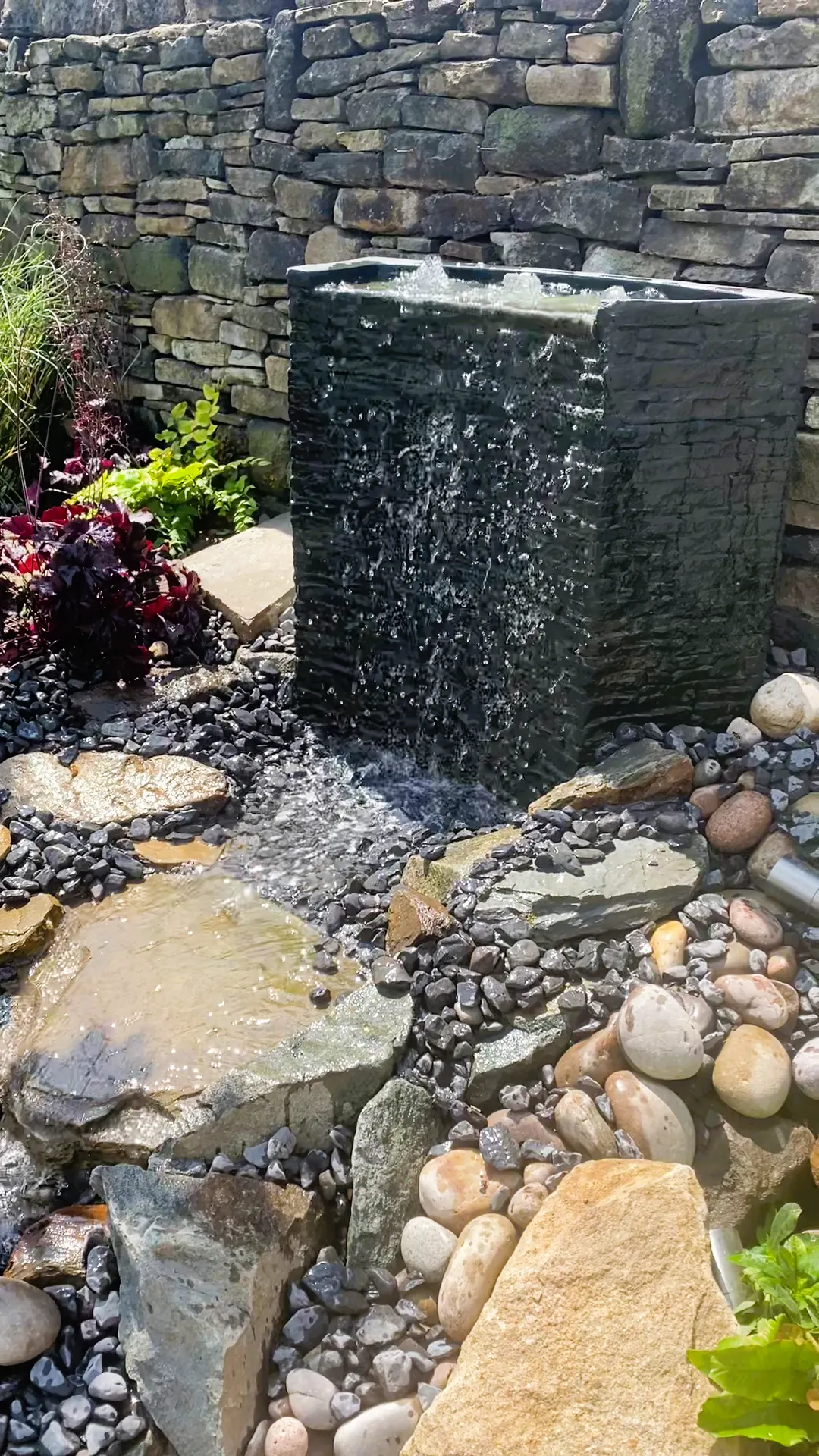 New water garden with natural stone and flowing water